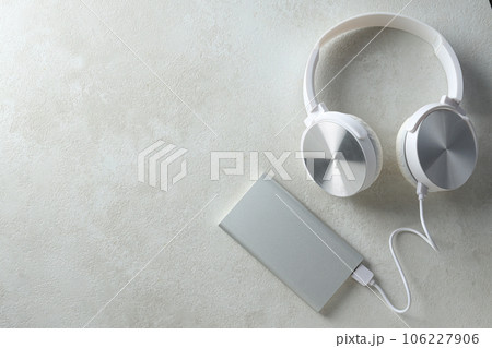 Powerbank, cord and headphones on gray background, space for text 106227906