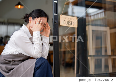 A crying and upset Asian female coffee shop owner feeling sad to close her business. A crying and upset Asian female coffee shop owner feeling sad to close her business. 106228612