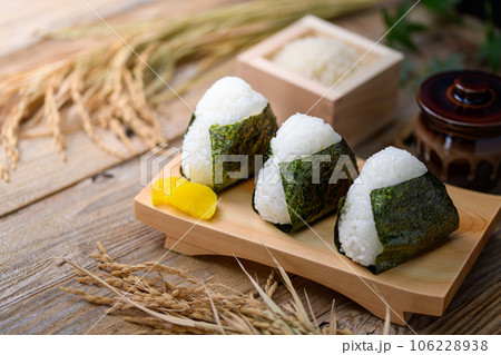 手作りおむすび 海苔を巻いたおにぎりと 枡に盛った米 ( オニギリ ) たくあんを添えて 手作りおむすび 海苔を巻いたおにぎりと 枡に盛った米 ( オニギリ ) たくあんを添えて 106228938
