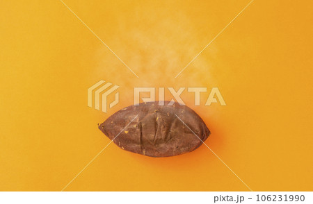 オレンジ色背景上の焼き芋（サツマイモ） 106231990