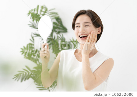 鏡を見て笑顔の女性　美容 106232080