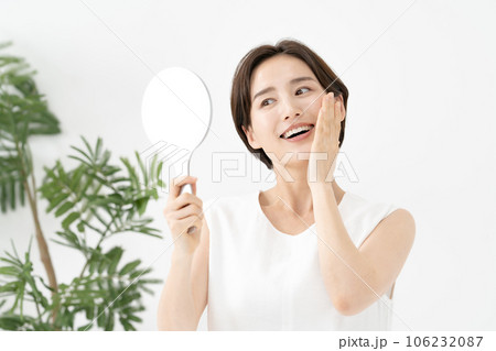 鏡を見て笑顔の女性　美容 106232087