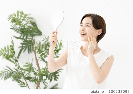 鏡を見て笑顔の女性　美容 106232095