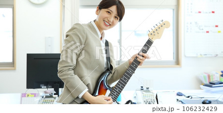 職場でエレキギターを演奏する女性会社員イメージ 106232429