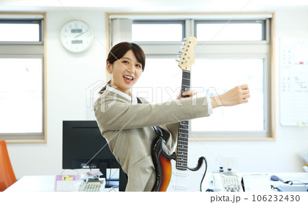 職場でエレキギターを演奏する女性会社員イメージ 職場でエレキギターを演奏する女性会社員イメージ 106232430
