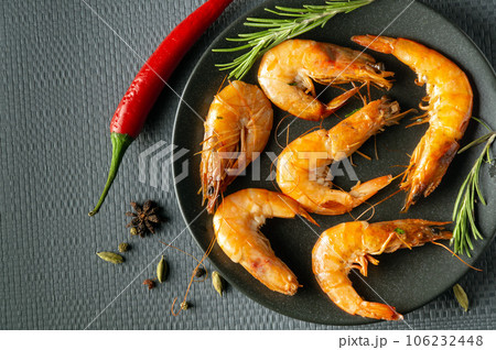 Shrimps or prawns with rosemary and pepper in a bowl on a gray table. The idea of dietary seafood for lunch or dinner Shrimps or prawns with rosemary and pepper in a bowl on a gray table. The idea of dietary seafood for lunch or dinner 106232448