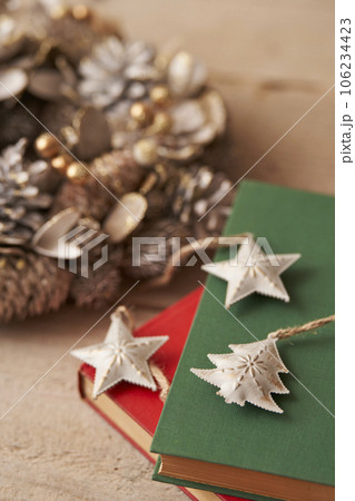 クリスマスイメージ  古い洋書の上に置かれたオーナメントとクリスマスリース 106234423