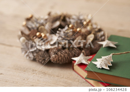 クリスマスイメージ  古い洋書の上に置かれたオーナメントとクリスマスリース 106234428