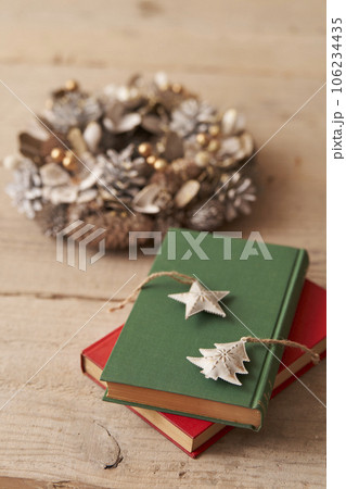 クリスマスイメージ 古い洋書の上に置かれたオーナメントとクリスマスリース クリスマスイメージ 古い洋書の上に置かれたオーナメントとクリスマスリース 106234435