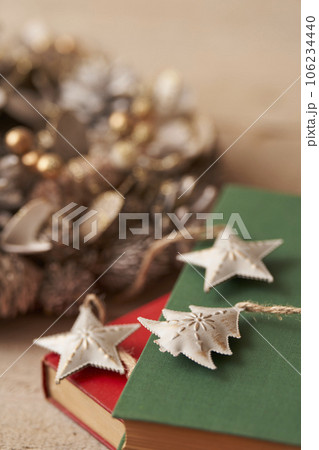 クリスマスイメージ 古い洋書の上に置かれたオーナメントとクリスマスリース クリスマスイメージ 古い洋書の上に置かれたオーナメントとクリスマスリース 106234440