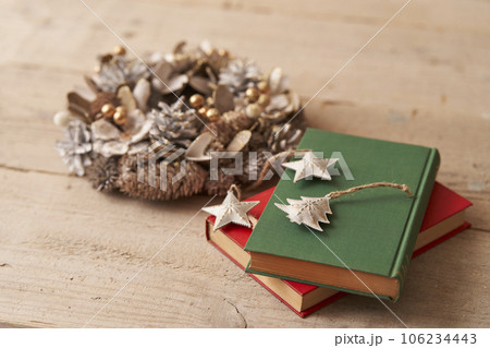 クリスマスイメージ  古い洋書の上に置かれたオーナメントとクリスマスリース 106234443