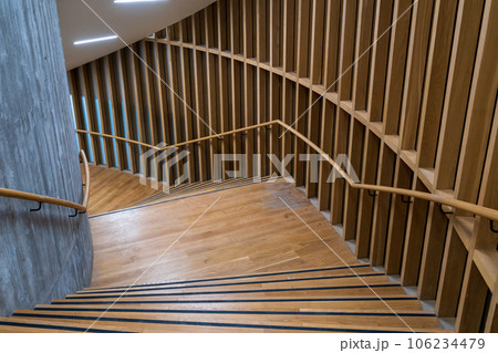 Railings made of wooden material placed on parquet floor surround and form empty small space under light Railings made of wooden material placed on parquet floor surround and form empty small space under light 106234479