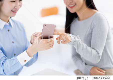 スマホを見せ合う女性・手元 スマホを見せ合う女性・手元 106234588