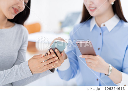 スマホを見せ合う女性・手元 スマホを見せ合う女性・手元 106234618
