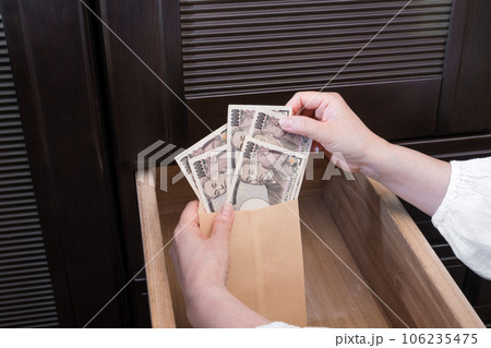【主婦がたんすの引き出しに封筒入りの一万円札を隠す】 106235475