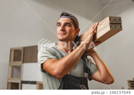 Portrait of young male carpenter standing in the wood workshop Portrait of young male carpenter standing in the wood workshop 106237049