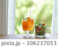 窓辺のテーブルの上に置かれた飲み物とサラダ 106237053