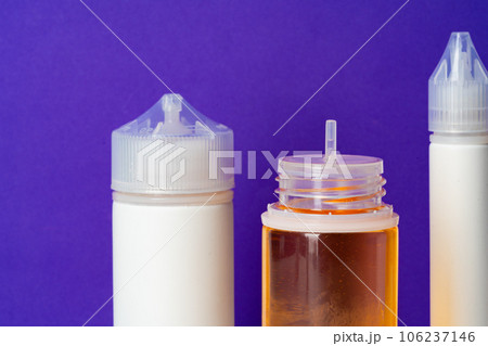 Electronic cigarettes liquid bottles on purple background 106237146