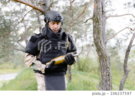 A man in a special suit works with a detector and found an explosive device 106237597