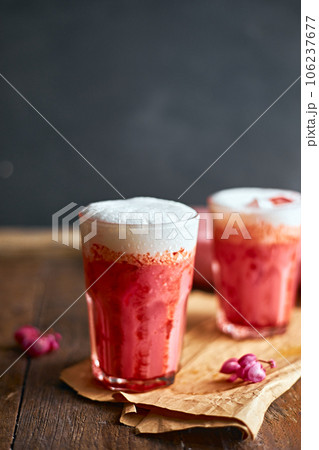 Thai style iced pink milk.Cold sweet drink Red Grenadien Sugar Syrup mix with milk and iced cube in glass Thai style iced pink milk.Cold sweet drink Red Grenadien Sugar Syrup mix with milk and iced cube in glass 106237677