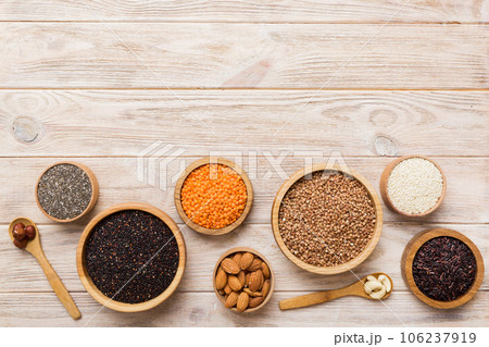 Various superfoods in smal bowl on colored background. Superfood as rice, chia, quinoa, lentils, nuts, sesame seeds, almonds. top view copy space Various superfoods in smal bowl on colored background. Superfood as rice, chia, quinoa, lentils, nuts, sesame seeds, almonds. top view copy space 106237919