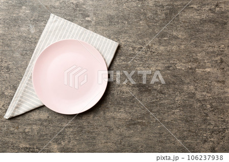Top view on colored background empty round pink plate on tablecloth for food. Empty dish on napkin with space for your design 106237938