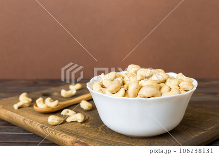 cashew nuts in wooden bowl on table background. top view. Space for text Healthy food cashew nuts in wooden bowl on table background. top view. Space for text Healthy food 106238131