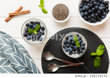 Healthy breakfast or morning with chia seeds vanilla pudding and blueberry berries on table background, vegetarian food, diet and health concept. Chia pudding with coconut milk and blueberry Healthy breakfast or morning with chia seeds vanilla pudding and blueberry berries on table background, vegetarian food, diet and health concept. Chia pudding with coconut milk and blueberry 106238132