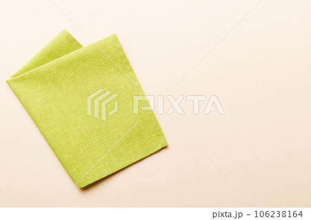 top view with green kitchen napkin isolated on table background. Folded cloth for mockup with copy space, Flat lay. Minimal style top view with green kitchen napkin isolated on table background. Folded cloth for mockup with copy space, Flat lay. Minimal style 106238164