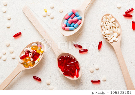 Vitamin capsules in a spoon on a colored background. Pills served as a healthy meal. Red soft gel vitamin supplement capsules on spoon Vitamin capsules in a spoon on a colored background. Pills served as a healthy meal. Red soft gel vitamin supplement capsules on spoon 106238203