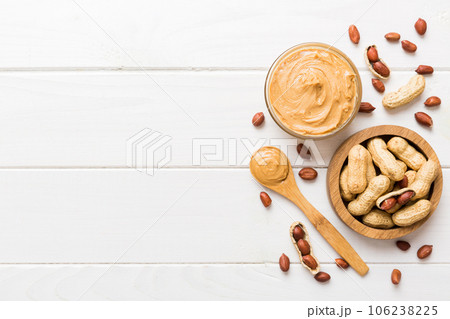 Bowl of peanut butter and peanuts on table background. top view with copy space. Creamy peanut pasta in small bowl Bowl of peanut butter and peanuts on table background. top view with copy space. Creamy peanut pasta in small bowl 106238225