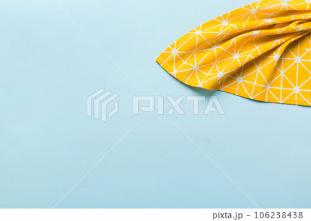 top view with yellow empty kitchen napkin isolated on table background. Folded cloth for mockup with copy space, Flat lay. Minimal style top view with yellow empty kitchen napkin isolated on table background. Folded cloth for mockup with copy space, Flat lay. Minimal style 106238438