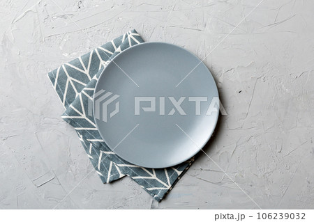 Top view on colored background empty round gray plate on tablecloth for food. Empty dish on napkin with space for your design 106239032