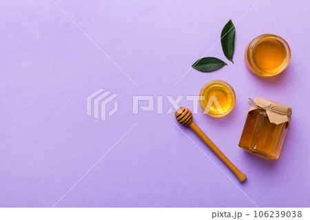 Honey jar with wooden honey dipper on white background top view with copy space. Delicious honey bottle Honey jar with wooden honey dipper on white background top view with copy space. Delicious honey bottle 106239038