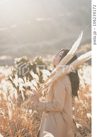 すすきの中パンパスグラスグラスを肩に乗せ目を閉じ上を向く女性 106239172