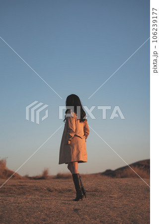 草原で流離うトレンチコートを着た女性 草原で流離うトレンチコートを着た女性 106239177