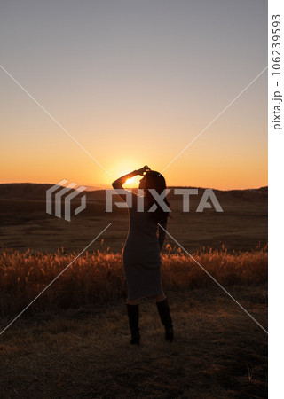 夕焼けの草千里で女性のシルエット 106239593