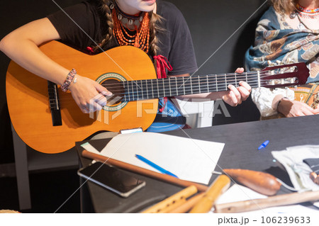A woman in folk clothes playing guitar A woman in folk clothes playing guitar 106239633