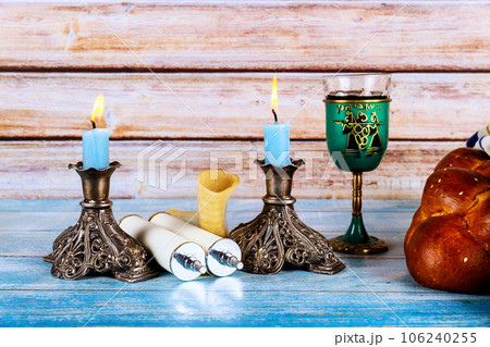 Embracing sabbath traditional jewish holiday with homemade challah bread, kosher wine, candles Embracing sabbath traditional jewish holiday with homemade challah bread, kosher wine, candles 106240255