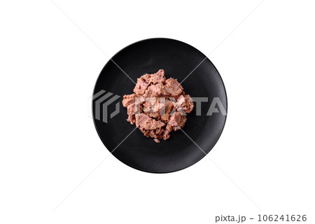 Delicious canned tuna meat on a black ceramic plate on a dark concrete background Delicious canned tuna meat on a black ceramic plate on a dark concrete background 106241626