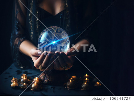 Female hands with crystal ball and burning candles in the dark, prediction session. 106241727