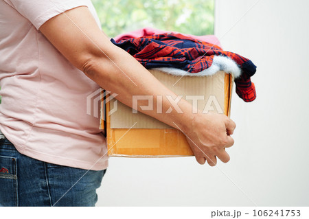 Clothes donations in cardboard box for volunteer. Clothes donations in cardboard box for volunteer. 106241753