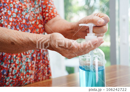 Asian senior woman press blue alcohol sanitizer gel for washing hand protect infection coronavirus. Asian senior woman press blue alcohol sanitizer gel for washing hand protect infection coronavirus. 106242722