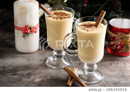 Homemade eggnog with cinnamon on wooden table. Typical Christmas dessert Homemade eggnog with cinnamon on wooden table. Typical Christmas dessert 106243058