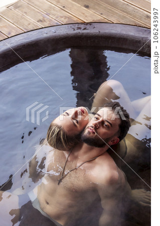young couple sitting in a tub filled with water 106243997