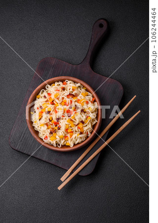 Delicious fresh Asian noodles with pieces of vegetables, meat, with salt, spices and herbs 106244464