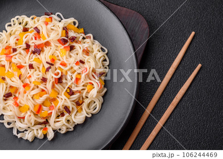 Delicious fresh Asian noodles with pieces of vegetables, meat, with salt, spices and herbs 106244469
