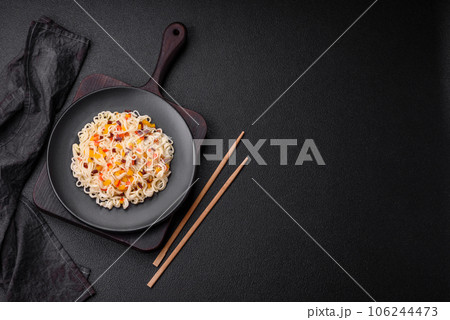 Delicious fresh Asian noodles with pieces of vegetables, meat, with salt, spices and herbs 106244473