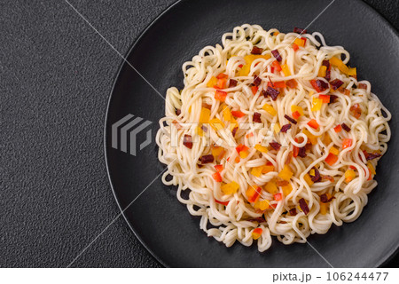 Delicious fresh Asian noodles with pieces of vegetables, meat, with salt, spices and herbs Delicious fresh Asian noodles with pieces of vegetables, meat, with salt, spices and herbs 106244477
