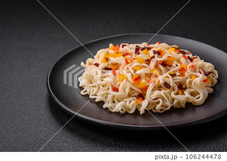 Delicious fresh Asian noodles with pieces of vegetables, meat, with salt, spices and herbs Delicious fresh Asian noodles with pieces of vegetables, meat, with salt, spices and herbs 106244478